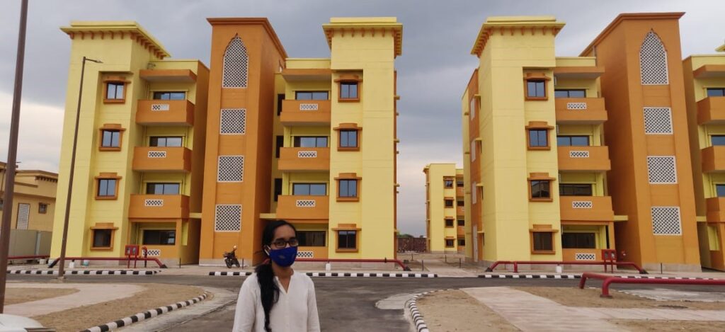 A picture of Sanya in front of buildings during a field visit during the internship at the RRP CISF Township