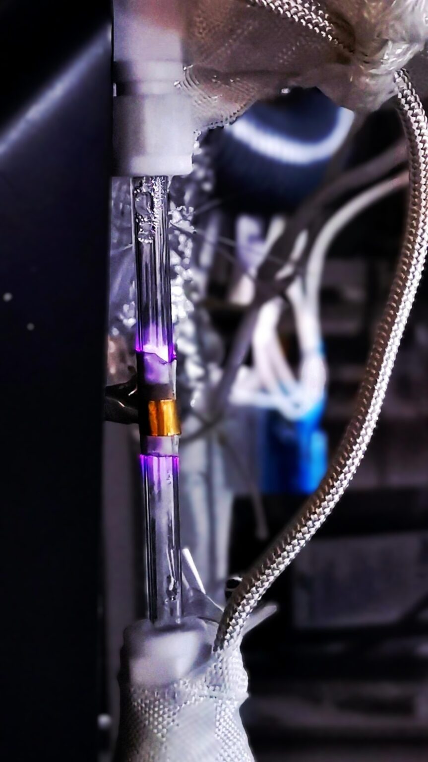 A plasma reactor produces a visible purple glow as energy drives chemical reactions