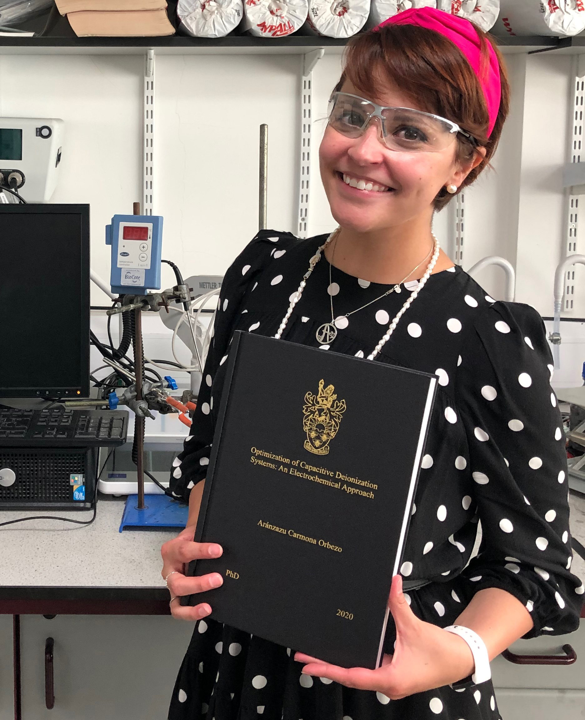 Aranza holding her completed PhD thesis