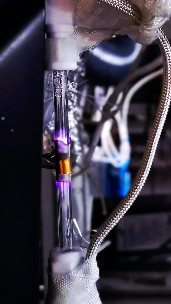 A plasma reactor produces a visible purple glow as energy drives chemical reactions