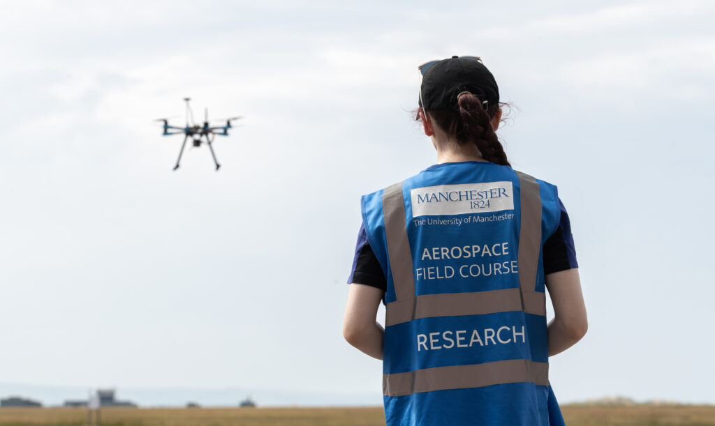 A PhD student pilots a drone during a test flight