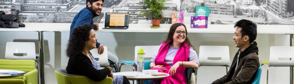 Group of smiling students around a table