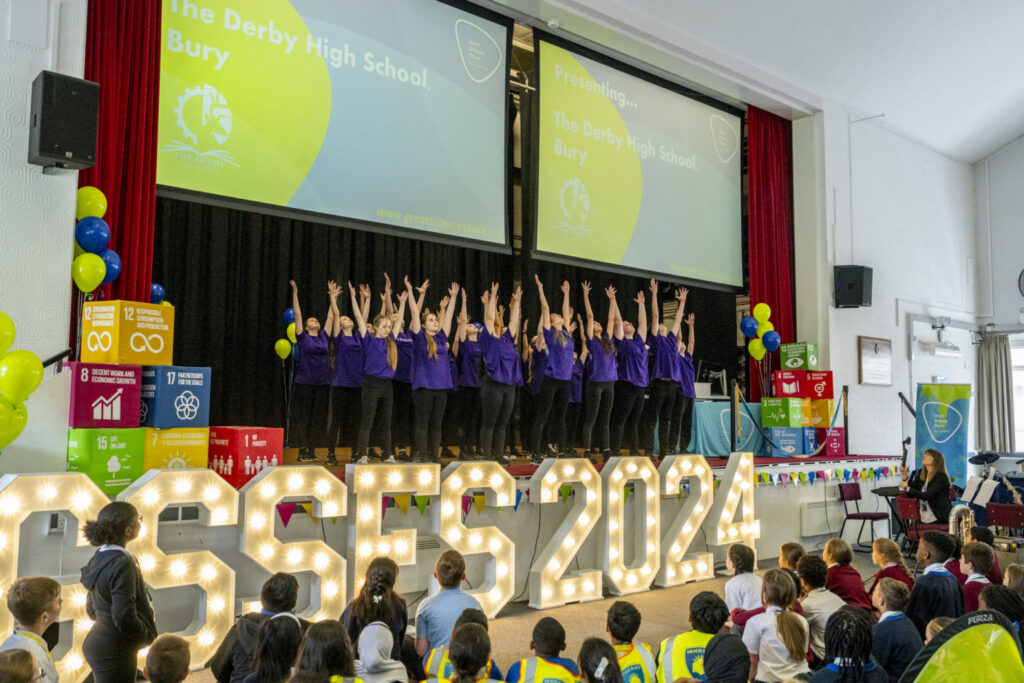 Children on stage with hands in the air