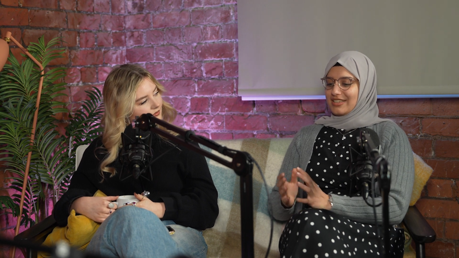 Two women sitting talking with a microphone in between