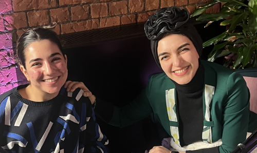 Two women smiling at the camera, behind microphones