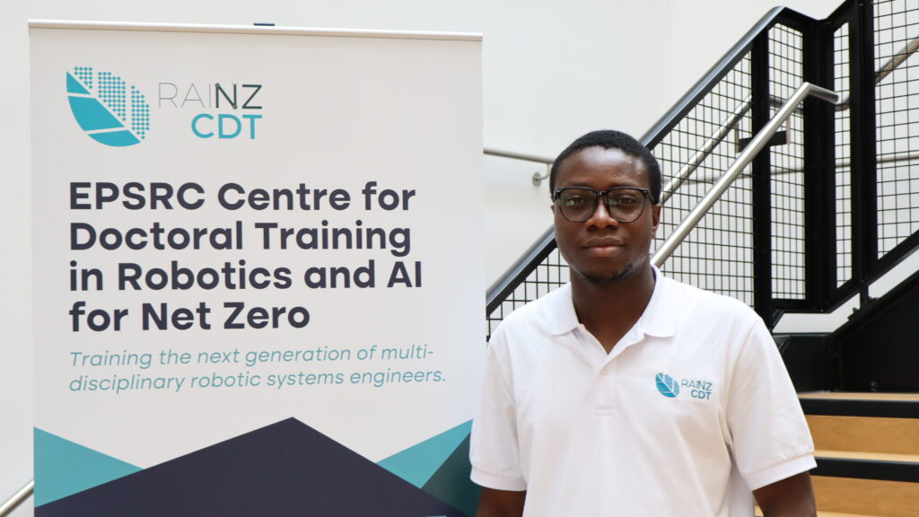 RAINZ CDT postgraduate researcher Ibrahim Aromoye with promotional RAINZ CDT banner
